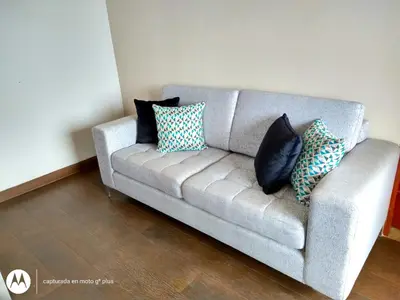 a couch with pillows on it in a living room at Residencial Cafferata in Lima