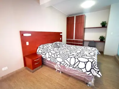 a bedroom with a bed with a black and white comforter at Residencial Cafferata in Lima