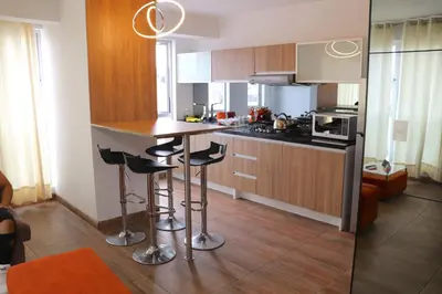 a kitchen with a counter and bar stools in it at Residencial Cafferata in Lima
