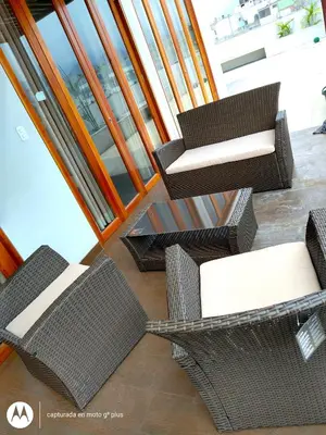 a group of wicker chairs and tables on a balcony at Residencial Cafferata in Lima
