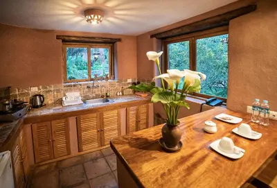 a kitchen with a table with a vase of flowers on it at Sacred Dreams Lodge in Urubamba