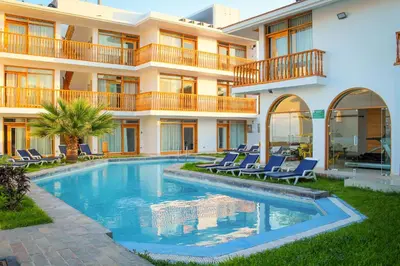 a swimming pool in front of a building at Hotel Boutique La Angostura in Ica