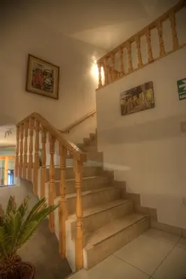 a wooden staircase in a house with a painting on the wall at Hotel Boutique La Angostura in Ica