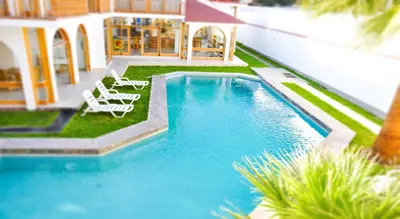 a swimming pool with lounge chairs next to a house at Hotel Boutique La Angostura in Ica