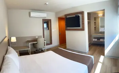 a hotel room with a bed and a desk and a television at DM Hoteles Nasca in Nazca