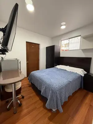 a bedroom with a bed and a desk and a television at Private room in Miraflores; Exclusive entrance! in Lima