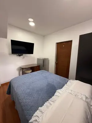 a bedroom with a bed and a tv on the wall at Private room in Miraflores; Exclusive entrance! in Lima