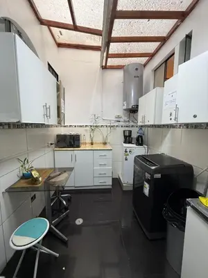 a kitchen with white cabinets and a table and a stove at Private room in Miraflores; Exclusive entrance! in Lima