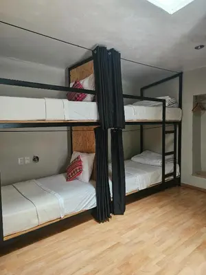 three bunk beds in a room with wooden floors at Xplora Hostel Cusco in Cusco