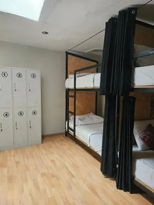 a room with two bunk beds and a wooden floor at Xplora Hostel Cusco in Cusco