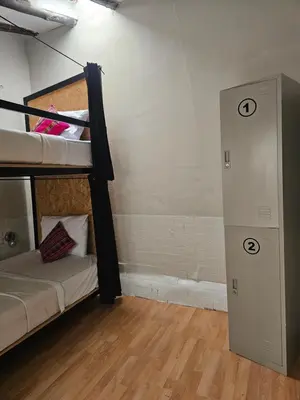 a room with two bunk beds and a door at Xplora Hostel Cusco in Cusco