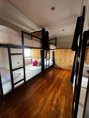 a room with two bunk beds and a wooden floor at Xplora Hostel Cusco in Cusco