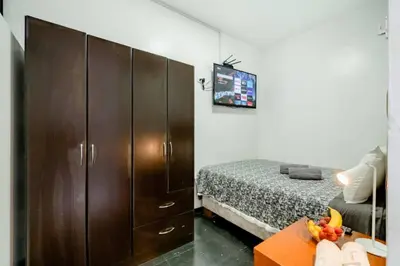 a bedroom with a bed and a large wooden cabinet at Room 5 Star Miraflores in Lima