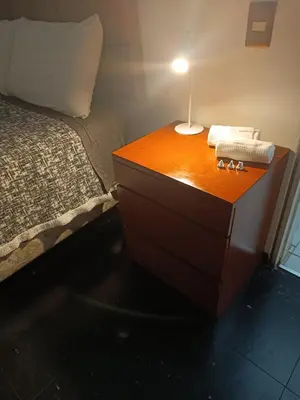 a wooden dresser with a lamp on it next to a bed at Room 5 Star Miraflores in Lima