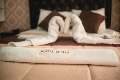 two hotel towels on a bed in a hotel room at Hostal Spring II in Huánuco