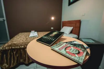 a table with a book on top of a bed at Hostal Spring II in Huánuco