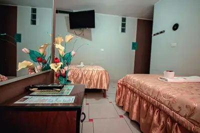 a hotel room with two beds and a mirror at Hostal Spring II in Huánuco