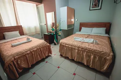 two beds in a hotel room with towels on them at Hostal Spring II in Huánuco