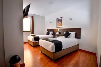 a hotel room with two beds and a window at Ankawa Hotel Boutique in Cusco