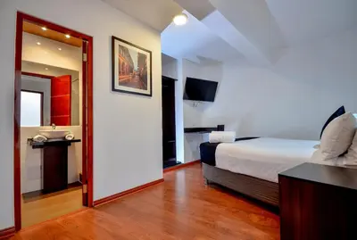 a hotel room with a bed and a bathroom at Ankawa Hotel Boutique in Cusco
