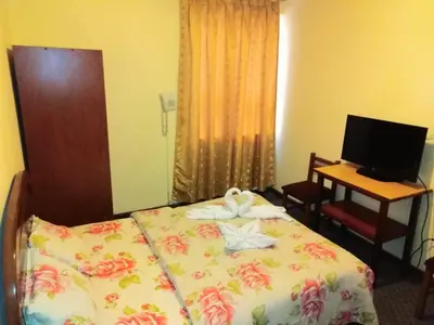 a bedroom with a bed and a desk with a computer at Hotel Mandarin in Lima