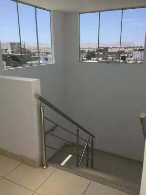 a staircase in an empty room with windows at Antares Paracas in Paracas