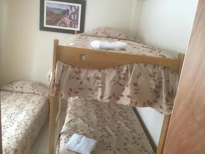 a bedroom with a bunk bed with a pillow and a chair at Antares Paracas in Paracas