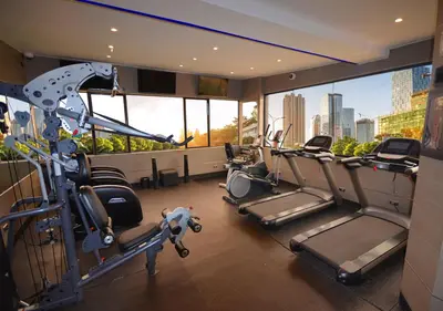 a gym with cardio equipment and a view of the city at qp Hotels Lima in Lima
