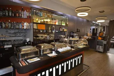 a restaurant with a counter with some food on it at qp Hotels Lima in Lima