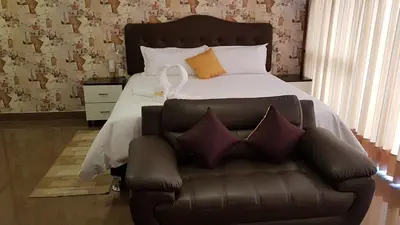 a bedroom with a bed and a leather couch at Hotel Costa Riviera in Mala