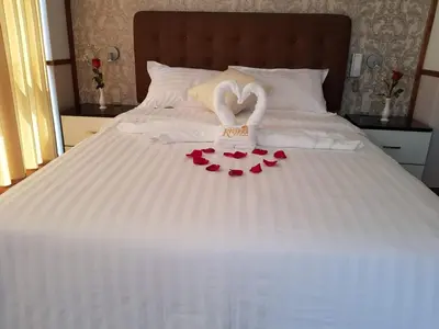 a bed with two hearts and two towels on it at Hotel Costa Riviera in Mala