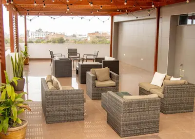 a lobby with wicker chairs and tables and chairs at Hotel Costa Riviera in Mala