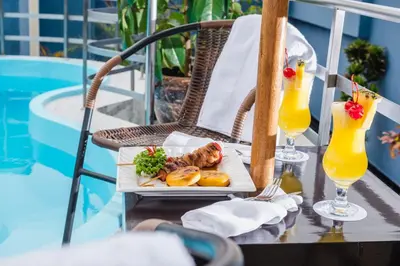 a plate of food on a table next to a pool at Nobility Grand Hotel in Lima