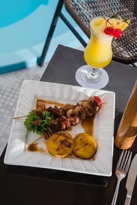 a plate of food on a table with a drink at Nobility Grand Hotel in Lima
