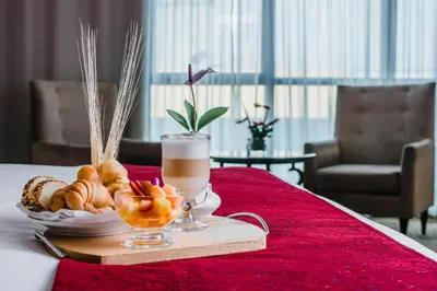 a tray of pastries and a drink on a table at Nobility Grand Hotel in Lima
