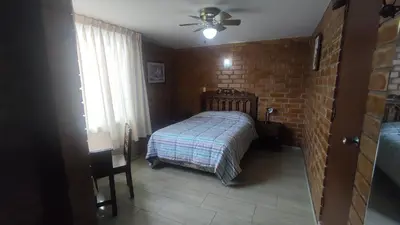 a bedroom with a bed and a brick wall at Hotel Esperanza in Lima