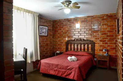 a bedroom with a red bed with two stuffed animals on it at Hotel Esperanza in Lima