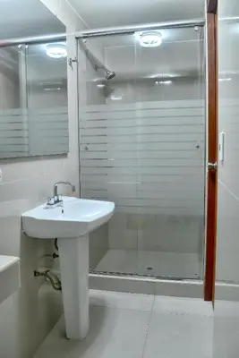 a bathroom with a sink and a glass shower at Hotel Esperanza in Lima