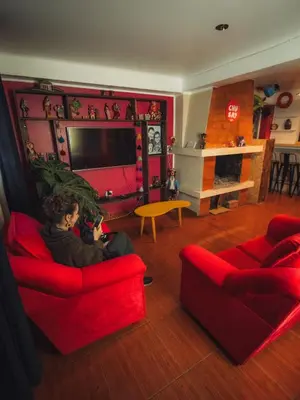 a woman sitting on a red couch in a living room at The Chusay Rooftop in Cusco