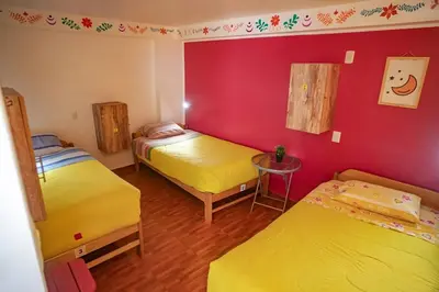a room with two beds and a red wall at The Chusay Rooftop in Cusco