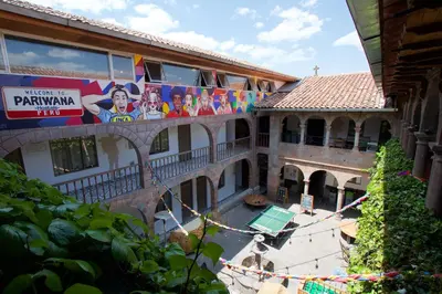 a building with a banner on the side of it at Pariwana Hostel Cusco in Cusco