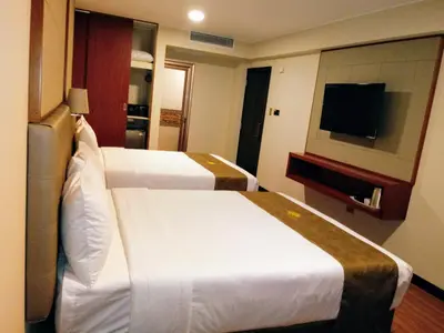 a hotel room with two beds and a flat screen tv at Hotel Candamo in Lima