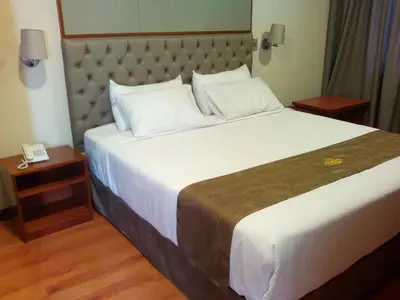 a large bed in a hotel room with a phone at Hotel Candamo in Lima