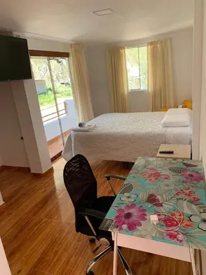a hotel room with a bed and a table with a desk at Alojamientos Támpur in San Mateo