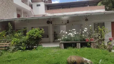 a house with a garden with white flowers in the yard at Alojamientos Támpur in San Mateo