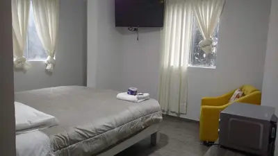 a bedroom with a bed and a tv and a yellow chair at Alojamientos Támpur in San Mateo