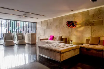 a living room with a couch and chairs in a room at Arawi Miraflores Prime in Lima