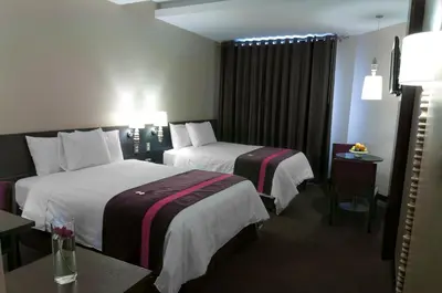 a hotel room with two beds and a table at Arawi Miraflores Prime in Lima