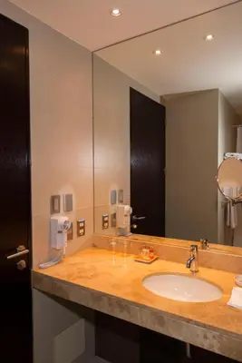 a bathroom with a sink and a large mirror at Arawi Miraflores Prime in Lima