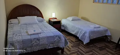 a bedroom with two beds and a lamp on a table at Lopez House in Lima